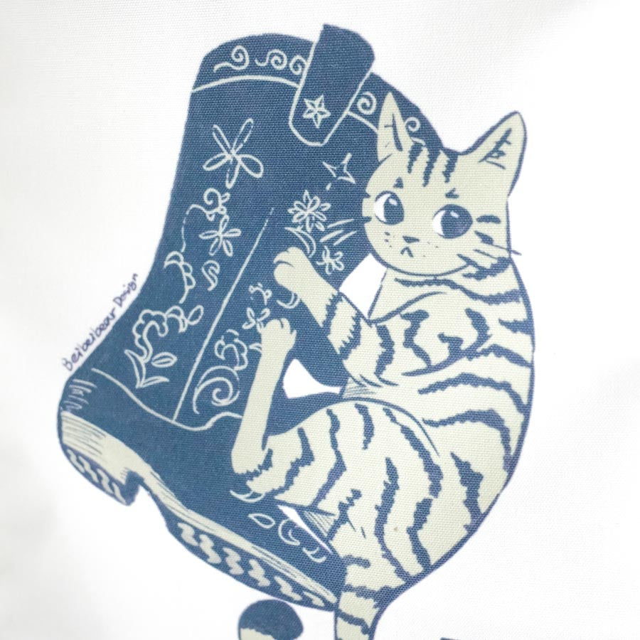 Close up on a canvas banner featuring simple illustration of a stripped cat hugging a floral cowboy boot