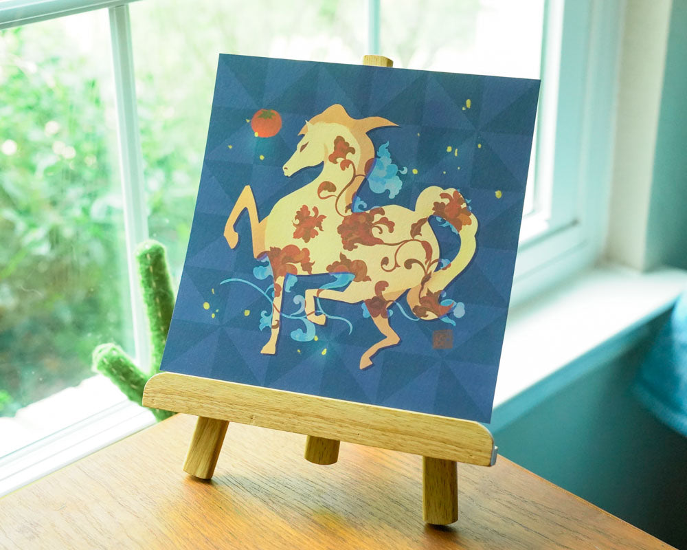 Decorative horse painting on a small easel against a window with greenery outside.