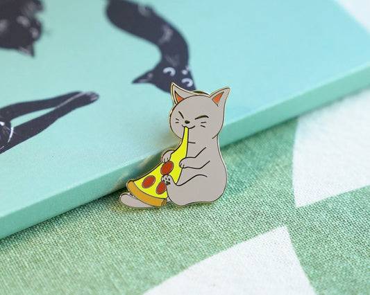 A pin featuring a gray cat happily eating a piece of pizza