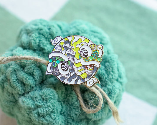 Decorative Chinese lion dancepin on a textured green surface